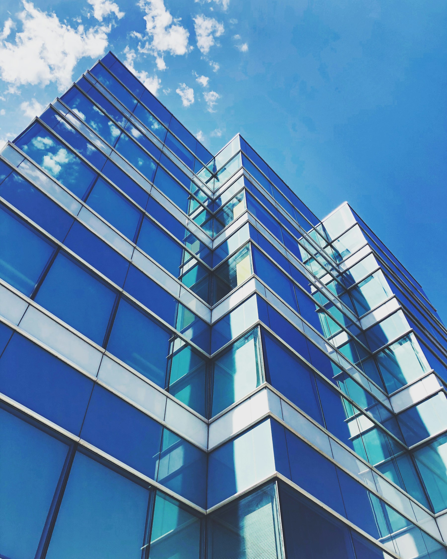 Glass architecture rising toward a clear blue sky